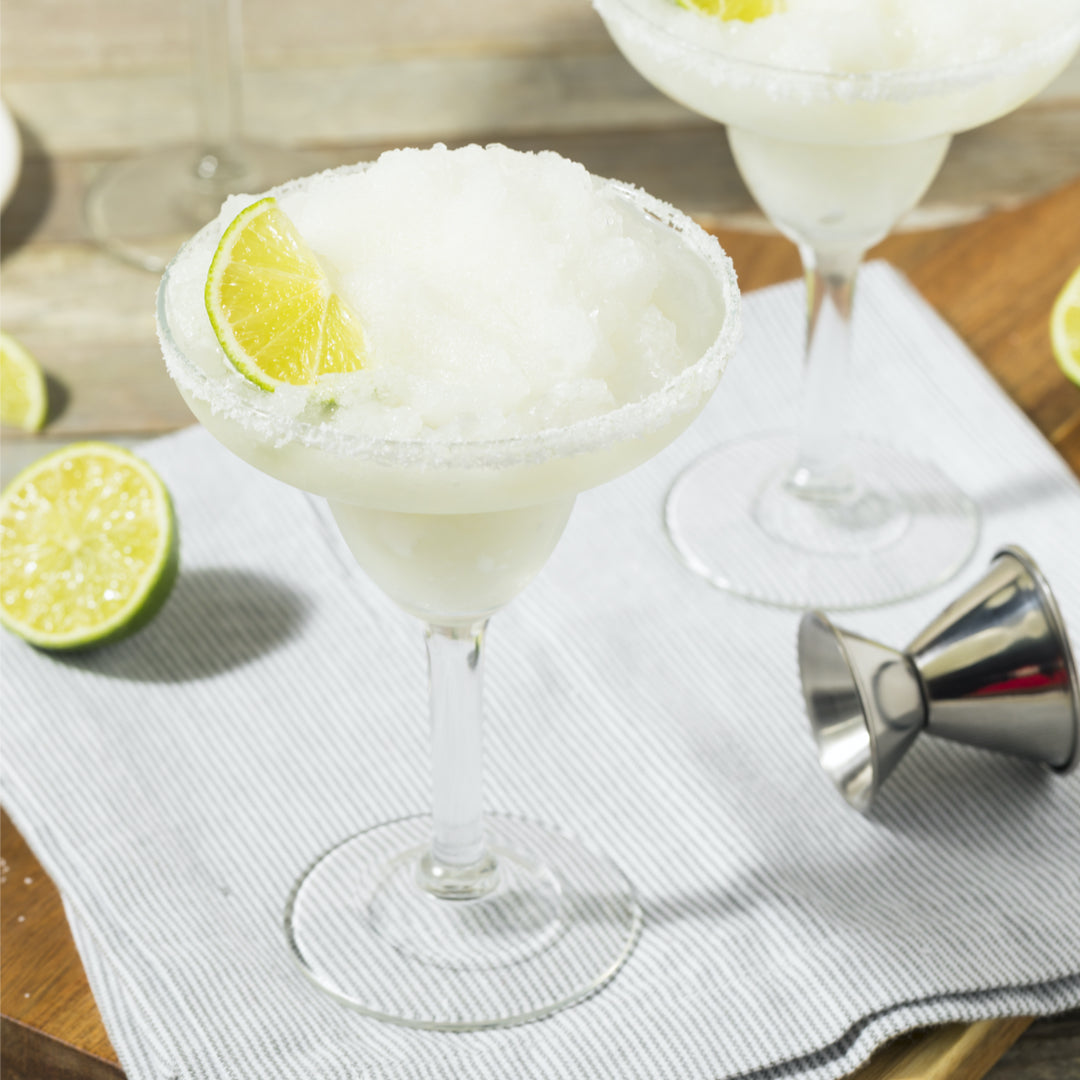 Snow white vermouth sorbet in a coupe glass and garnished with fresh lime